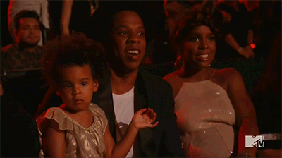 Blue Ivy no colo do pai, Jay Z, observa a apresentação da mãe, Beyoncé