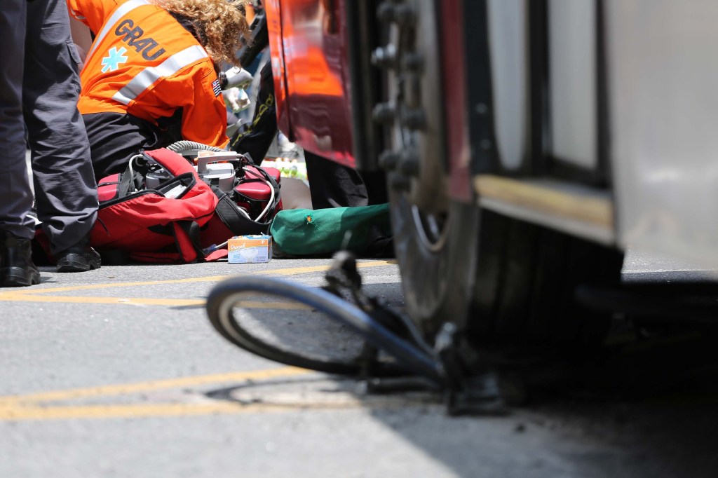 O ciclista Marlon Moreira de Castro é atendido por equipes de resgate, após ser atropelado por um ônibus na Avenida Paulista, em São Paulo