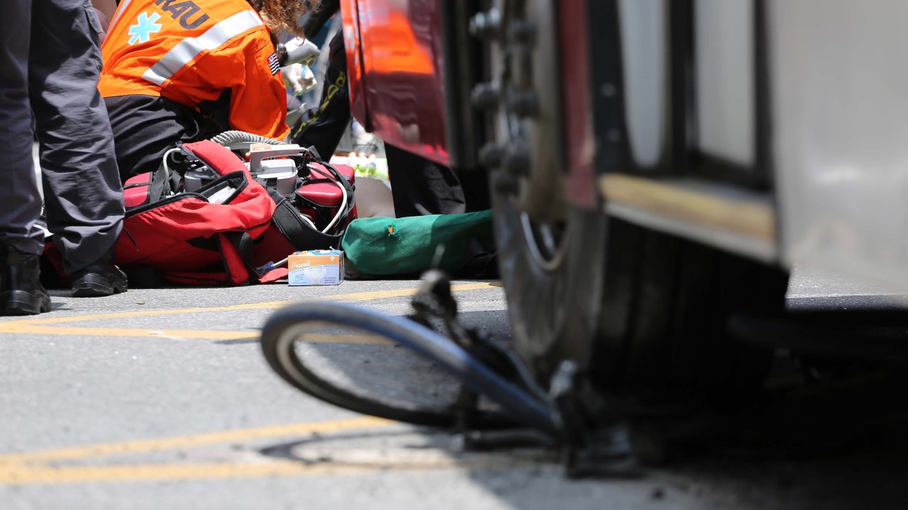 O ciclista Marlon Moreira de Castro é atendido por equipes de resgate, após ser atropelado por um ônibus na Avenida Paulista, em São Paulo