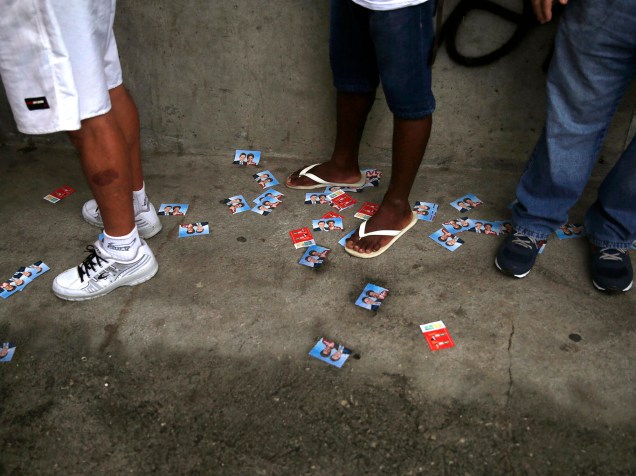 Eleitores aguardam em fila para votar, na manhã deste domingo (26), na favela da Rocinha, no Rio de Janeiro
