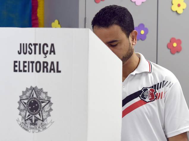 Homem vota em um posto de uma escola pública em Brasília, na manhã deste domingo (26), na capital federal