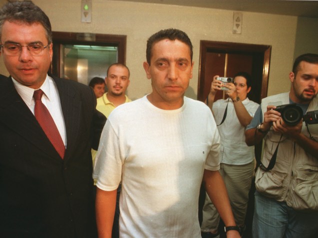 O empresário Sergio Gomes da Silva (no centro), que estava com o prefeito de Santo André, Celso Daniel, no momento em que ele foi sequestrado, sendo conduzido para prestar depoimento