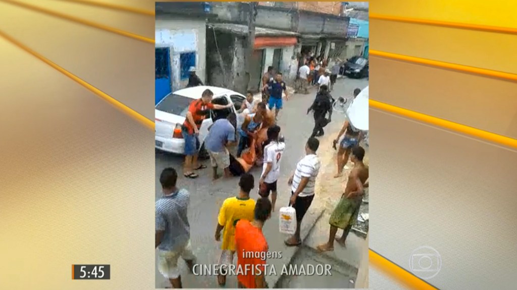 Mulher é carregada após ser atingida por uma bala perdida durante tiroteio no Complexo do Alemão no Rio de Janeiro. No mesmo local, um menino de 10 anos foi morto no dia seguinte