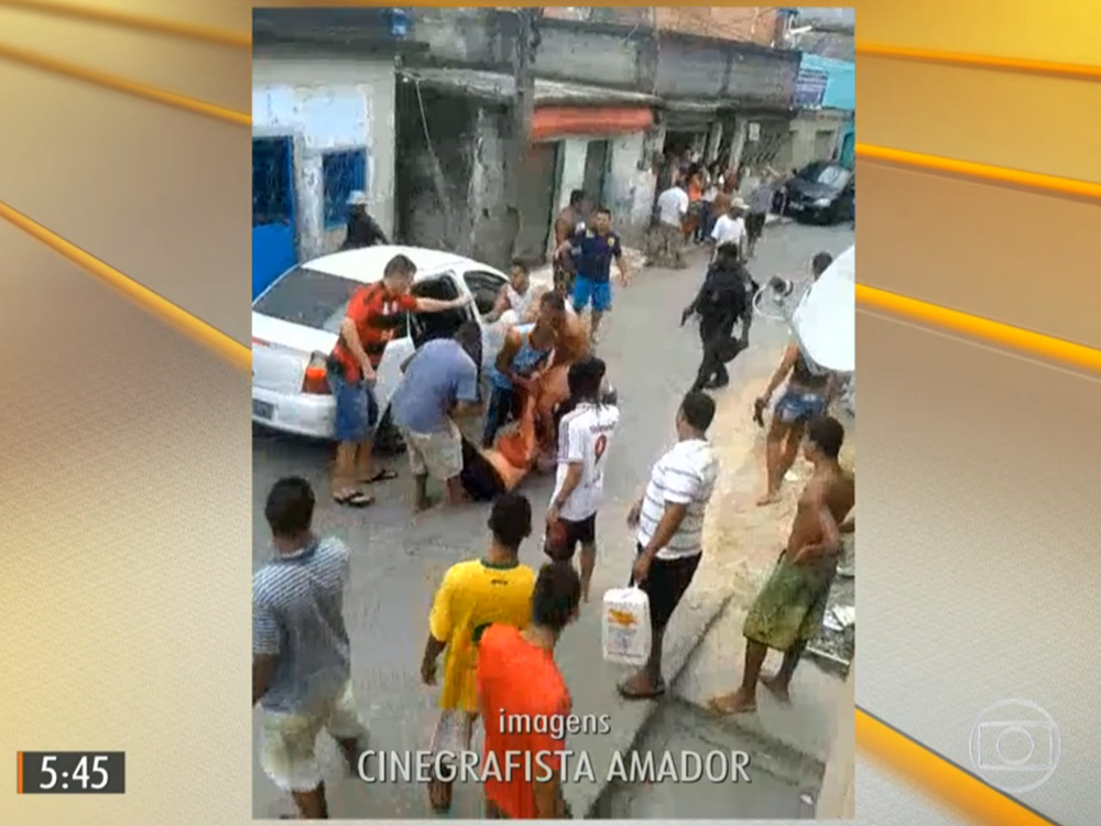 Mulher é carregada após ser atingida por uma bala perdida durante tiroteio no Complexo do Alemão no Rio de Janeiro
