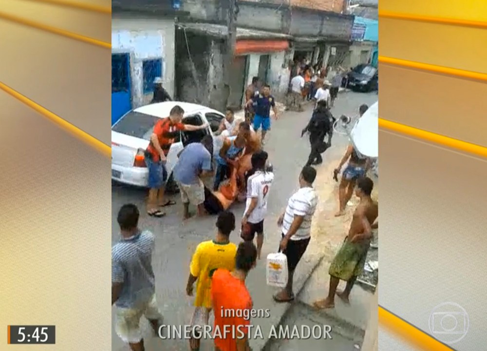 Mulher é carregada após ser atingida por uma bala perdida durante tiroteio no Complexo do Alemão no Rio de Janeiro