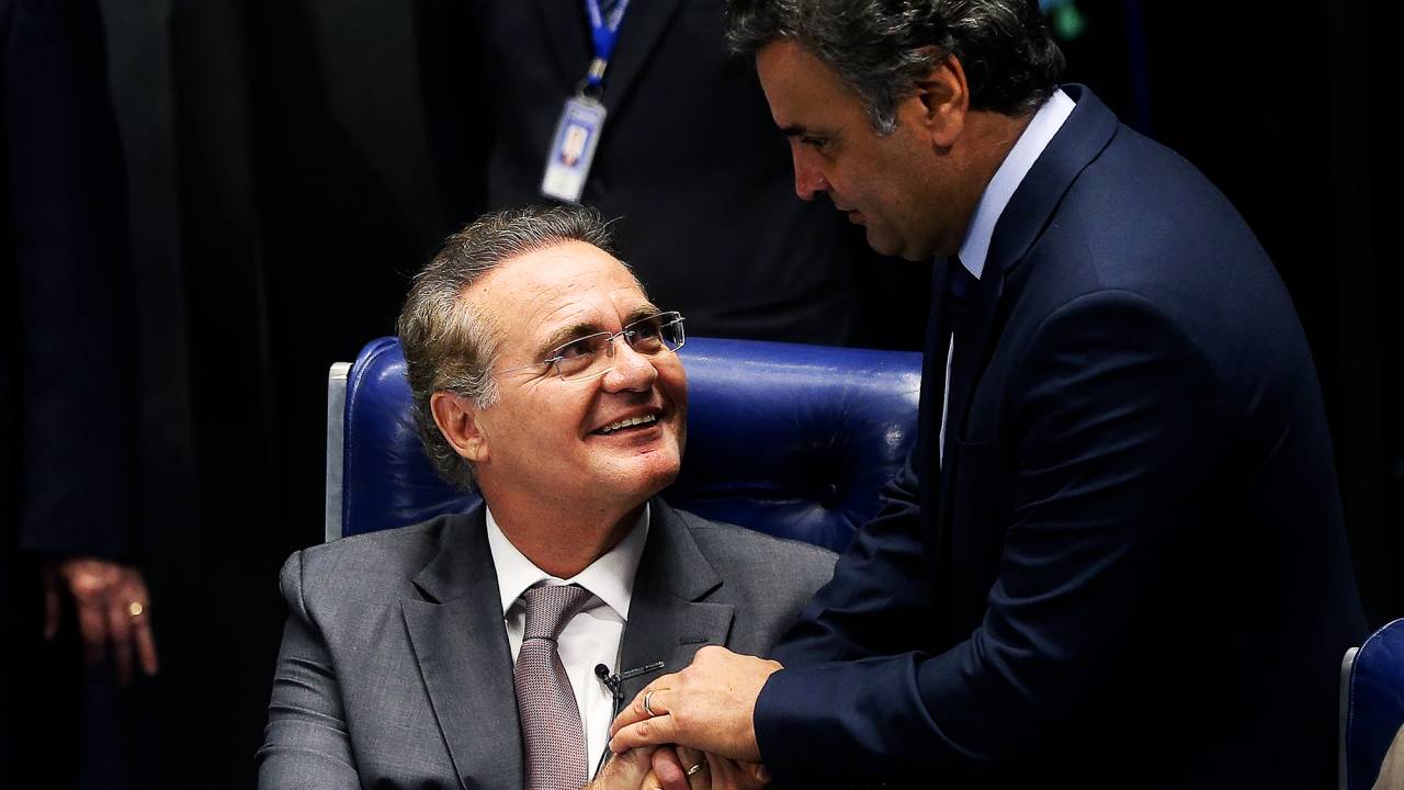 O senador Aécio Neves (PSDB) cumprimenta o senador Renan Calheiros (PMDB-AL), após anuncio. Renan Calheiros anunciou em plenário do Senado Federal, no Congresso Nacional, em Brasília (DF), a devolução ao governo federal da medida provisória 669/2015 que trata da desoneração da folha de pagamento das empresas