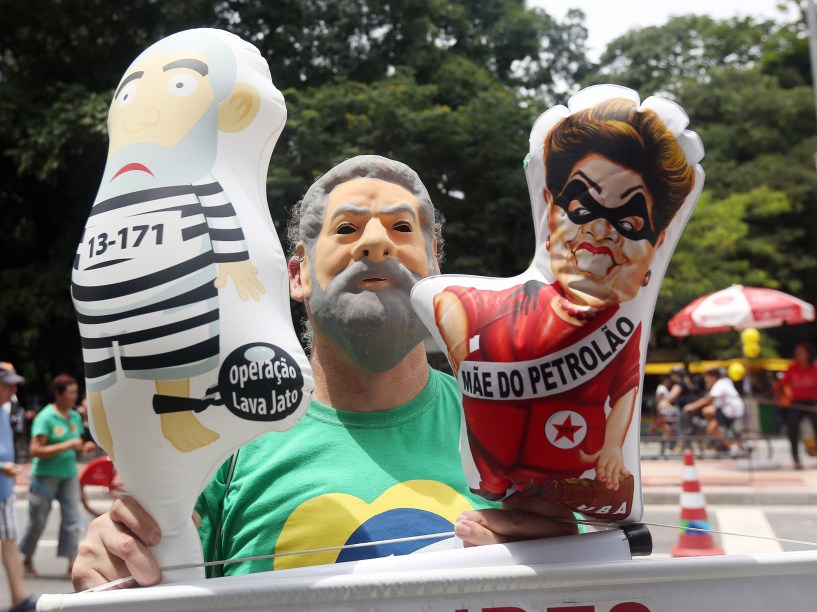 Manifestante com uma máscara do ex-presidente Lula segura bonecos infláveis durante protesto que pede o impeachment da presidente Dilma Rousseff na Avenida Paulista em São Paulo - 13/12/2015
