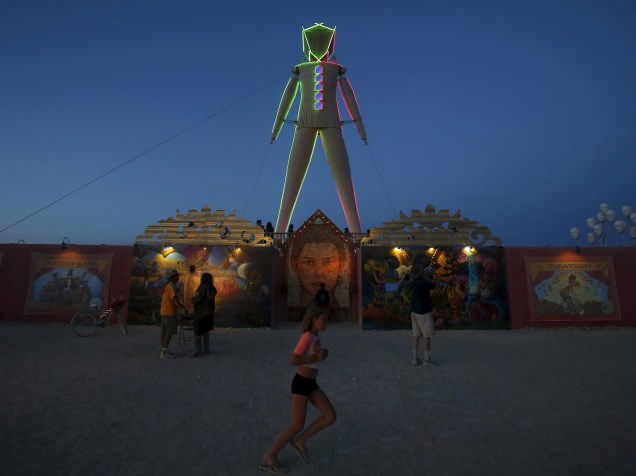 Escultura de madeira que dá nome ao festival é iluminada ao anoitecer durante o "Burning Man 2015: Carnaval de Espelhos". Cerca de 70.000 pessoas de todo o mundo se reúnem para passar a semana no deserto de Nevada durante o festival