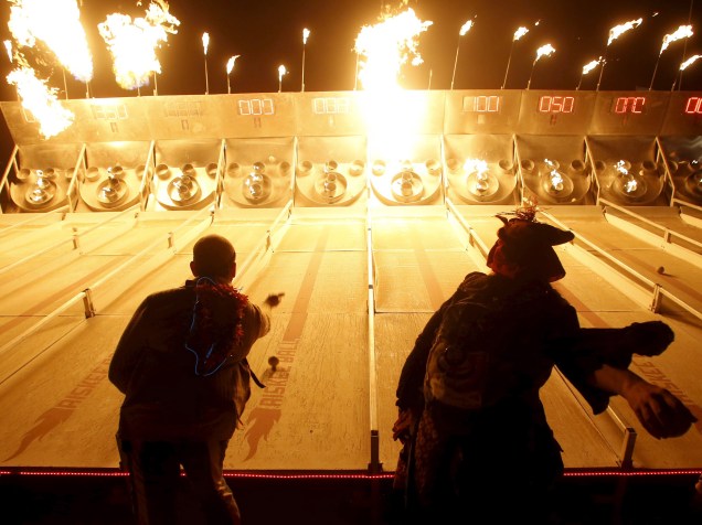Pessoas participam de um jogo de skee-ball em chamas durante o "Burning Man 2015: Carnaval de Espelhos". Cerca de 70.000 pessoas de todo o mundo se reúnem para passar a semana no deserto de Nevada durante o festival