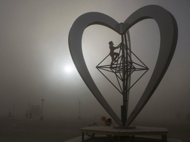 Participante interage com instalação artística "Metaheart" em meio a uma tempestade de areia durante o "Burning Man 2015: Carnaval de Espelhos". A festa tradicional é marcada por música e arte, e acontece no deserto de Black Rock, Nevada