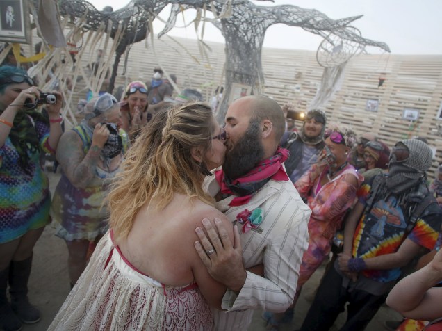 Casal se beija durante uma cerimônia de casamento realizada em pleno "Burning Man 2015: Carnaval de Espelhos". Cerca de 70.000 pessoas de todo o mundo se reúnem para passar a semana no deserto de Nevada durante o festival