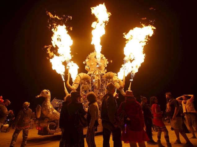 Participantes se juntam para observar as chamas que saem do veículo artístico "El Popo Mechanico" durante o "Burning Man 2015: Carnaval de Espelhos". A festa tradicional é marcada por música e arte, e acontece no deserto de Black Rock, Nevada