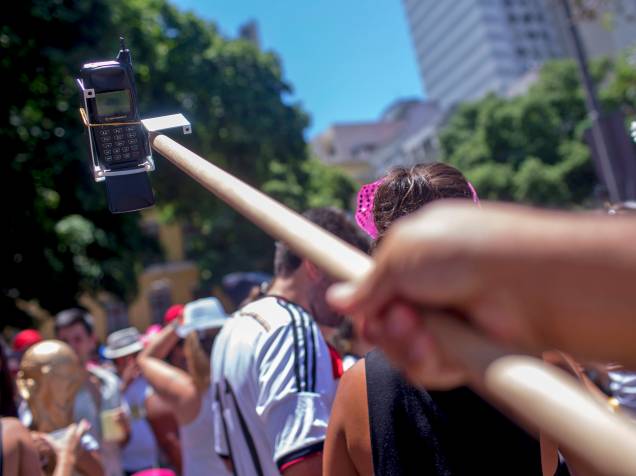 Homem imita um pau-de-selfie com um aparelho celular antigo durante o bloco Fogo e Paixão, que aconteceu na manhã deste domingo (08) no centro do Rio de Janeiro