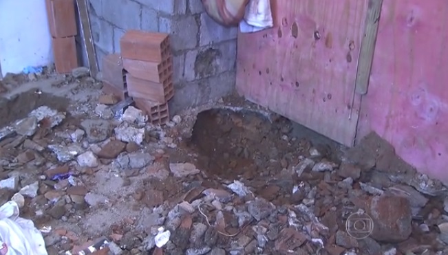 O piso revirado na casa onde seis corpos e ossadas foram encontrados na Favela Alba, em São Paulo