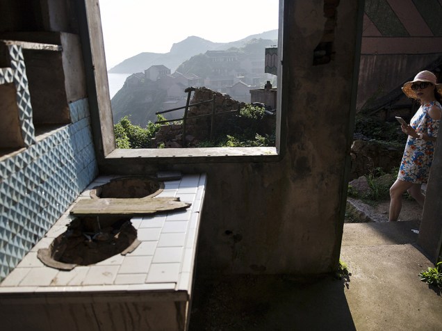Vegetação cobre quase totalmente as casas da aldeia abandonada de Houtouwan, na ilha de Shengshan, na China