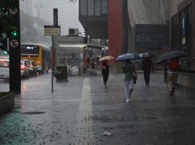 Pedestres se protegem da chuva na Av. Paulista, região central de São Paulo, na tarde desta quarta-feira (25)