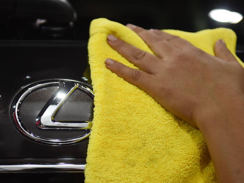 Mulher passa um pano em um Lexus apresentado no Salão do Automóvel 2014, em São Paulo