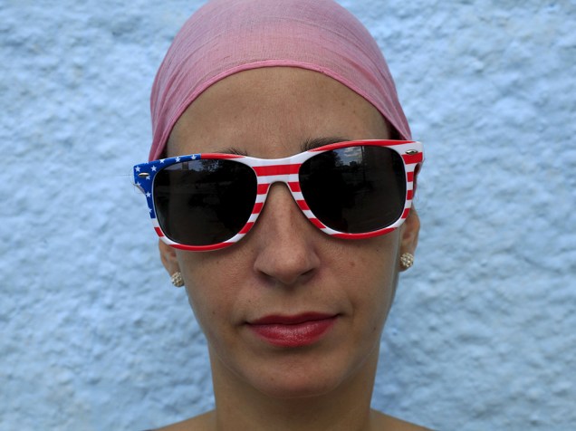Garota cubana usa óculos com estampa da bandeira dos Estados Unidos, em homenagem ao presidente Obama que visitará o país nas próximas semanas