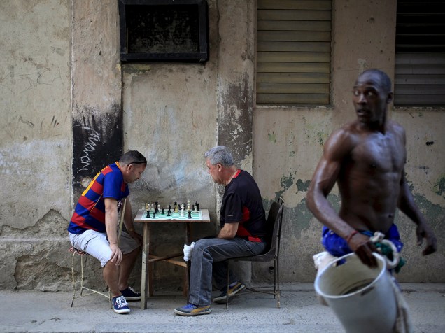 Cotidiano em Havana mostra dois cubanos jogando xadrez. O país se prepara para receber a visita emblemática do Presidente Barack Obama, nas próximas semanas