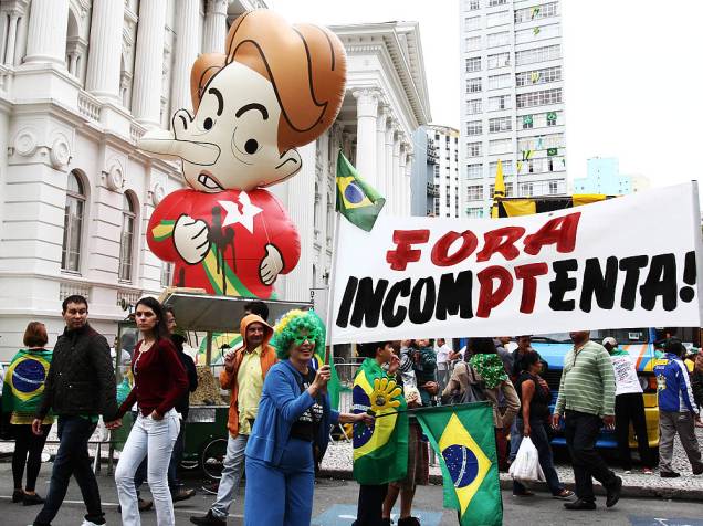 Manifestantes contrários ao governo Dilma Rousseff inflam boneco da presidente durante ato pelo impeachment na Praça Santos Andrade, em Curitiba (PR), neste domingo (13)
