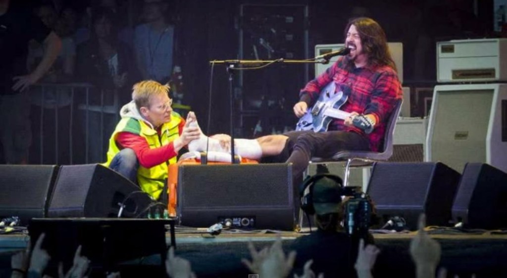 Dave Grohl de perna imobilizada, depois de ir ao hospital buscar socorro e voltar ao palco de Gotemburgo, Suécia