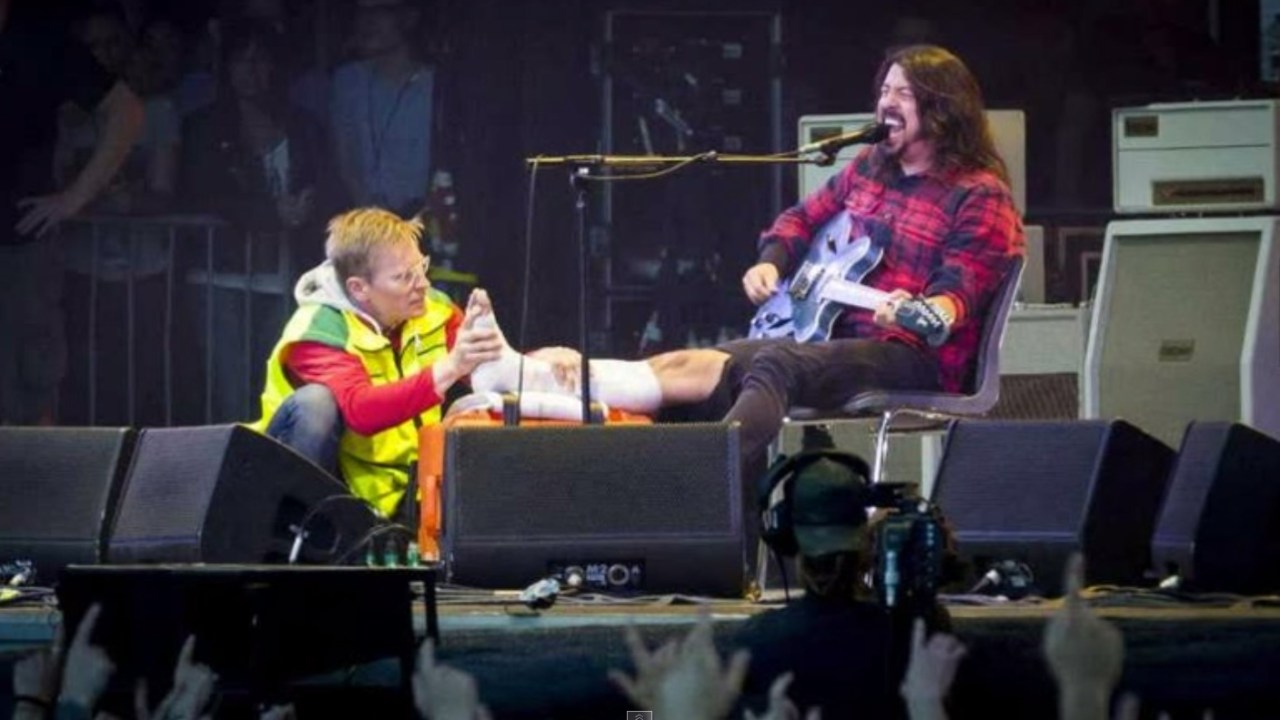 Dave Grohl de perna imobilizada, depois de ir ao hospital buscar socorro e voltar ao palco de Gotemburgo, Suécia