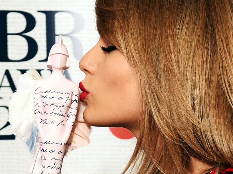 Taylor Swift beija a estatueta de Melhor Artista Internacional Feminina Solo durante o Brit Awards 2015