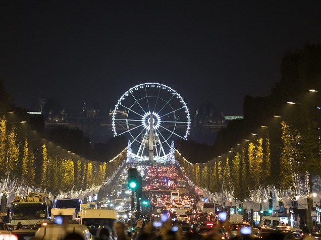 Milhares de lâmpadas enfeitam árvores e a famosa roda gigante da Avenida Champs Elysees, em Paris, França