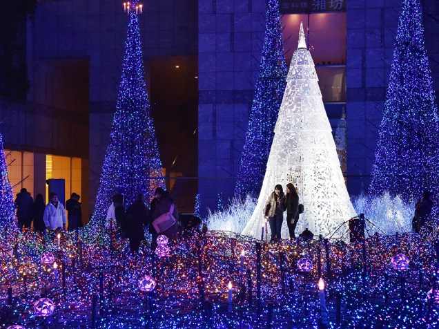 Dezenas de pessoas tiram fotos em meio as decorações natalianas de um shopping no Japão