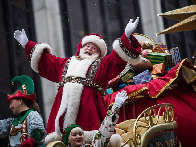Homem vestido de Papai Noel acena para a multidão durante desfile em Nova York, nos Estados Unidos