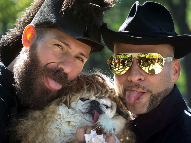 Homens posam com cachorro durante o desfile anual de Halloween da Tompkins Square, em Nova York, EUA