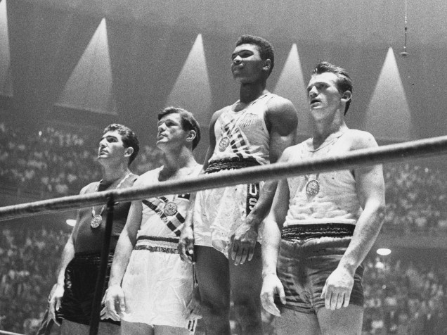 Muhammad Ali (ainda com o nome de Cassius Clay) no alto do pódio com a medalha de ouro nos jogos olímpicos de Roma em 1960