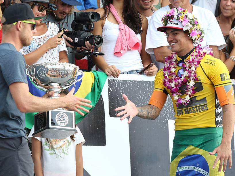 Gabriel Medina recebe o troféu do surfista Mick Fanning e comemora o título do Circuito Mundial de Surfe (WCT), no Billabong Pipe Masters, praia de Pipeline, Ilha de Oahu, no Havaí