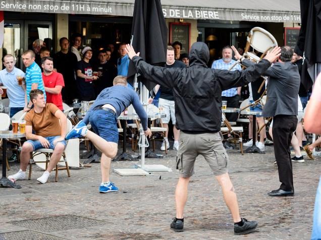 Homem joga uma cadeira enquanto um grupo de torcedores russos provocam um grupo de torcedores ingleses no centro de Lille, na França - 14/06/2016