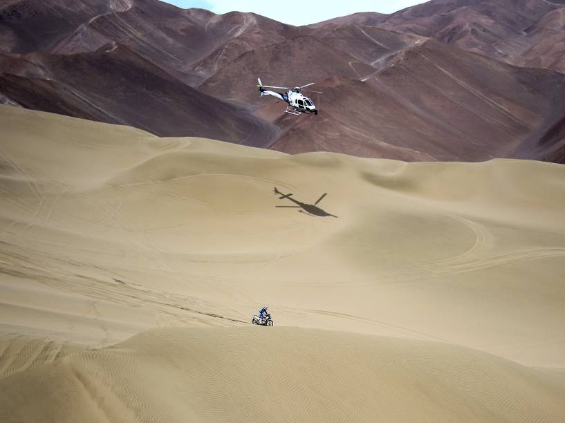 O piloto espanhol Juan Pedrero Garcia é acompanhado por um helicóptero durante a oitava etapa entre Bolívia e Chile