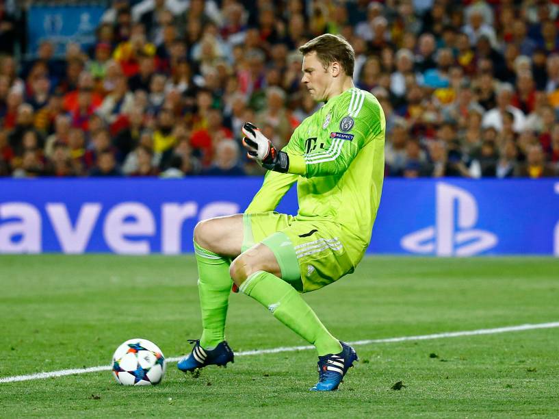 O goleiro Manuel Neuer do Bayern defende com os pés a tentativa do ataque do Barcelona