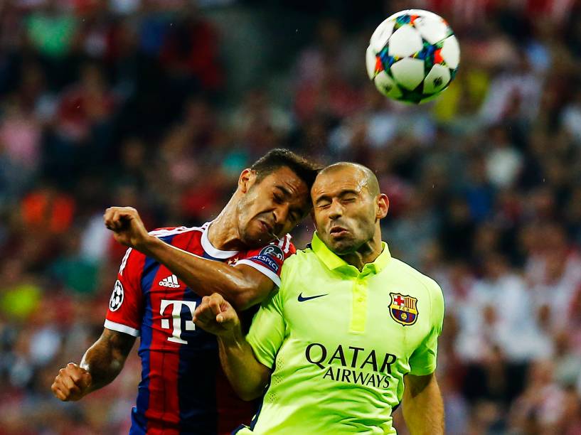 Thiago Alcântara do Bayern de Munique divide pelo alto com o volante Javier Mascherano do Barcelona