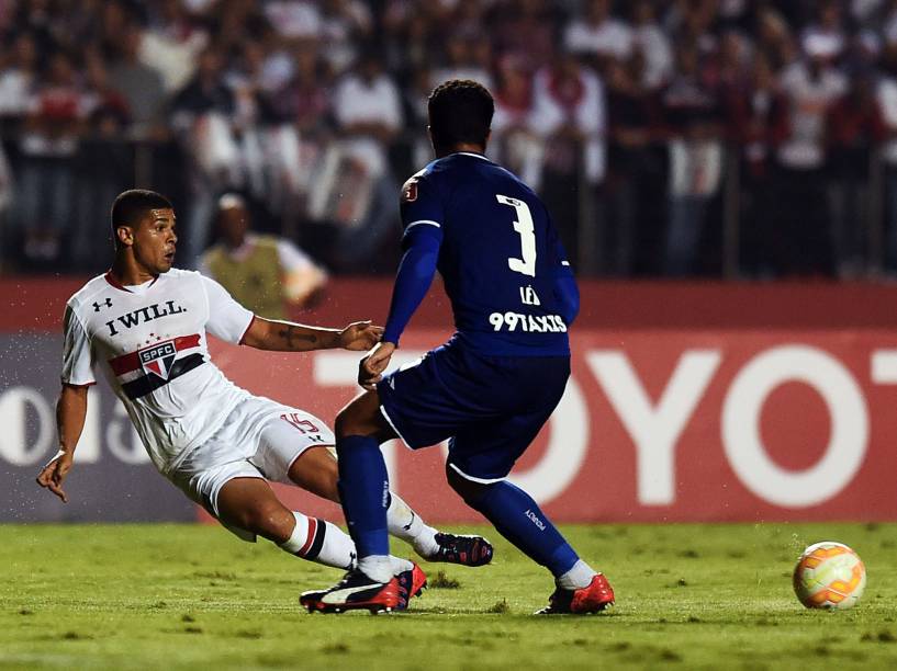 O volante Denílson do São Paulo passa a bola enquanto é marcado pelo zagueiro Léo do Cruzeiro