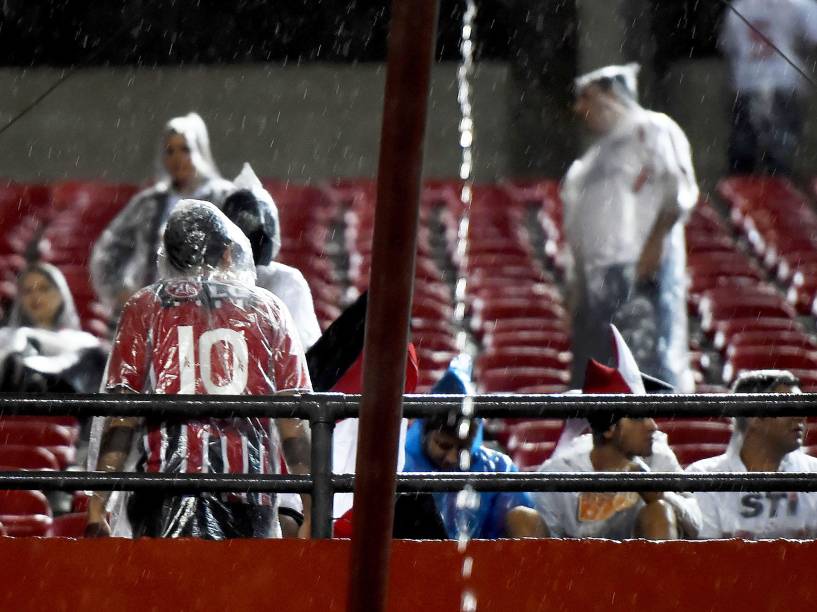 Torcida do São Paulo tenta se proteger da chuva na partida contra Danúbio do Uruguai, pela Libertadores - 25/02/2015
