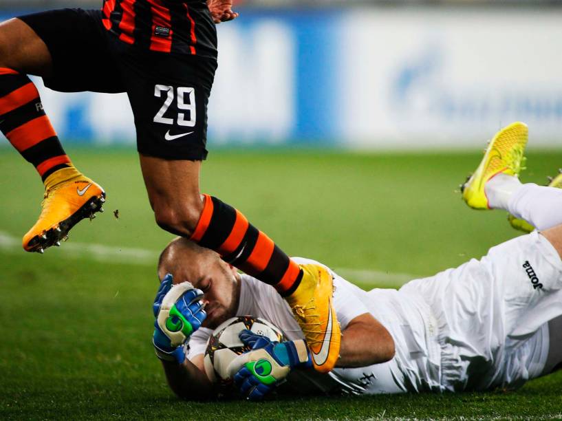 Goleiro do BATE Baryssau, Sergei Chernik, defende bola dos pés de Alex Teixeira, do Shakhtar Donetsk durante jogo pela Liga dos Campeões