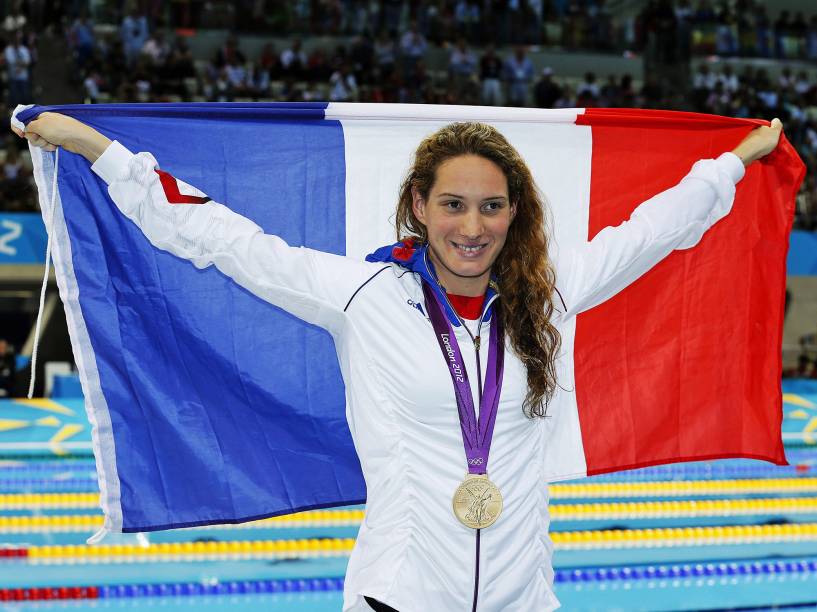 Camille Muffat levanta bandeira da França após ganhar a medalha de ouro nos 400m livre feminino e bater o record na categoria durante competição de natação das Olimpíadas de Londres, em 2012