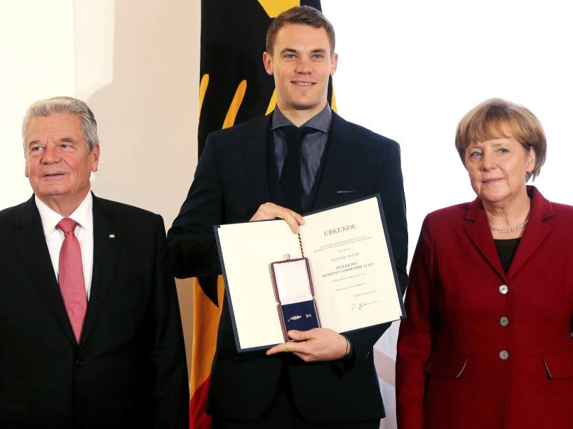 Goleiro Manuel Neuer posa com o presidente Joachim Gauck (à esq.) e a chanceler Angela Merkel depois de receber a condecoração Laurel de Prata, o principal prêmio da Alemanha para o sucesso desportivo, no Palácio Presidencial Schloss Bellevue, em Berlim
