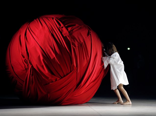 Garota empurra uma imensa bola de tecido durante a apresentação de Jacquemus na Paris Fashion Week