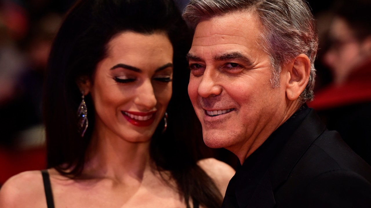 Ator americano George Clooney, e sua esposa Amal Alamuddin, posa para fotógrafos, na chegada ao tapete vermelho,para o filme 'Ave, César!', que será exibido na abertura do Festival de cinema de Berlim, na Alemanha, nesta quinta (11)