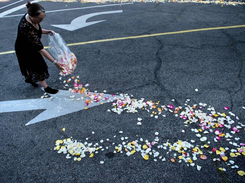 Mulher joga pétalas de flores na entrada do cemitério Cave Hill antes da chegada cortejo fúnebre da lenda do boxe Muhammad Ali em Louisville - 10/06/2016