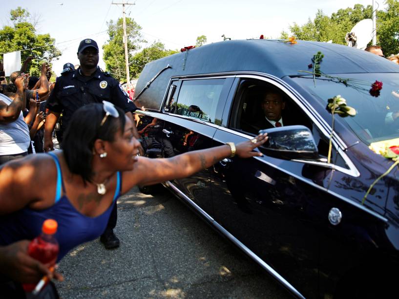 Mulher tenta alcançar carro do serviço funerário que carrega o caixão de Muhammad Ali, durante seu enterro em Kentucky