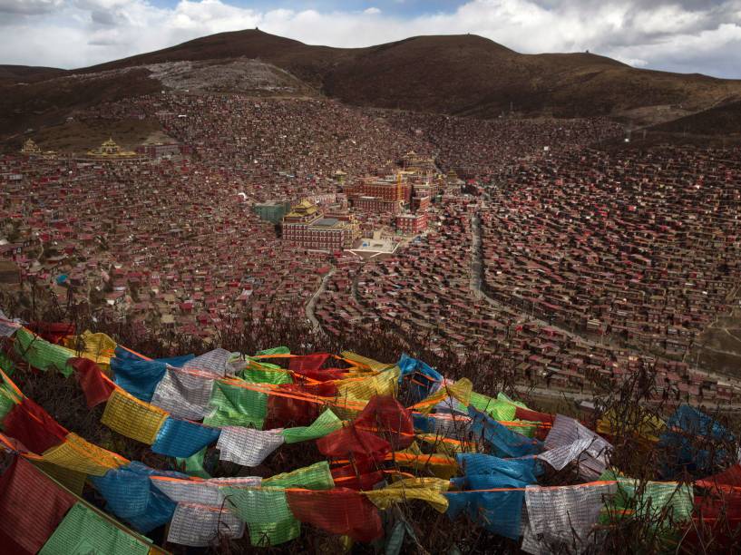 Bandeiras tibetanas de oração, conhecidas como Lung-ta, são vistas em uma colina acima do Instituto budista Larung Gar