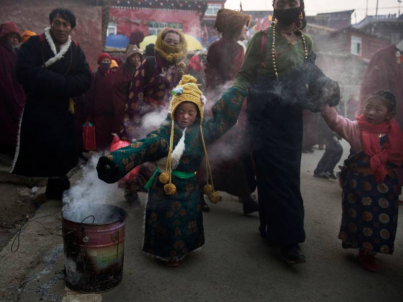 Menina caminha através da fumaça de zimbro para receber uma bênção antes de participar de uma sessão de cânticos