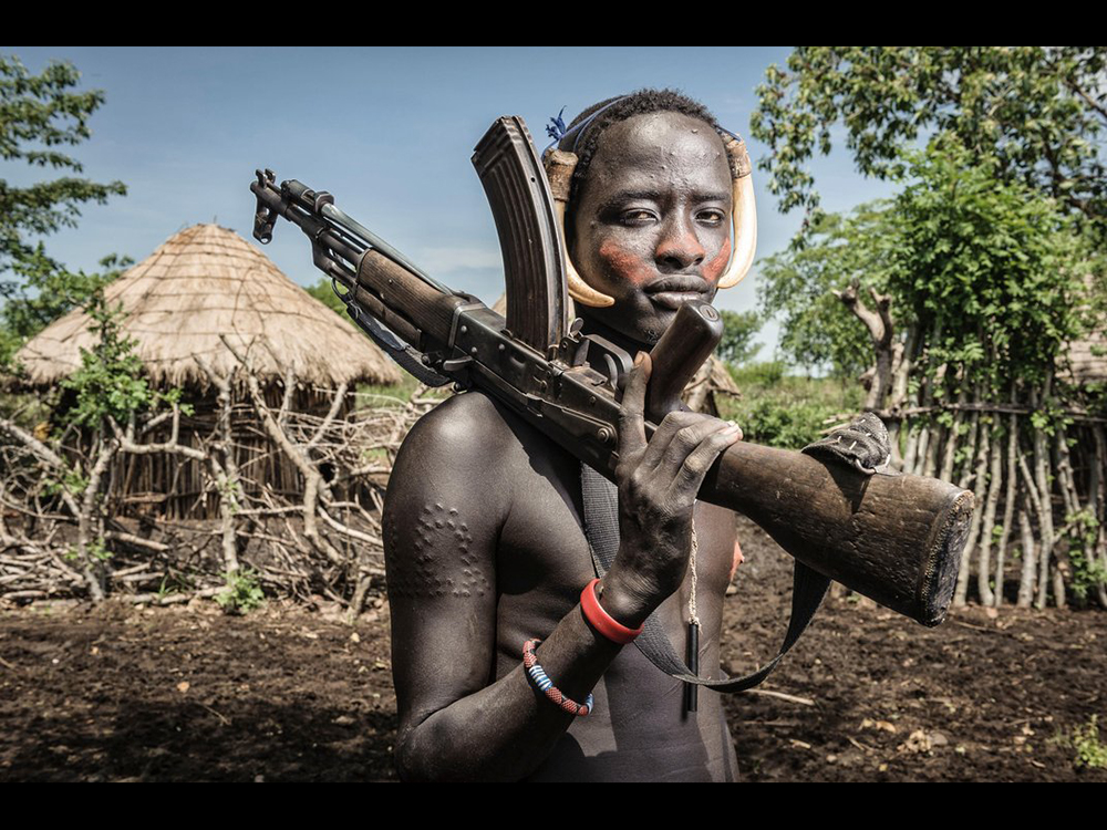 Homem da tribo 'Mursi' segura uma arma AK-47, em Marenke, Omo Valley, na Etiópia