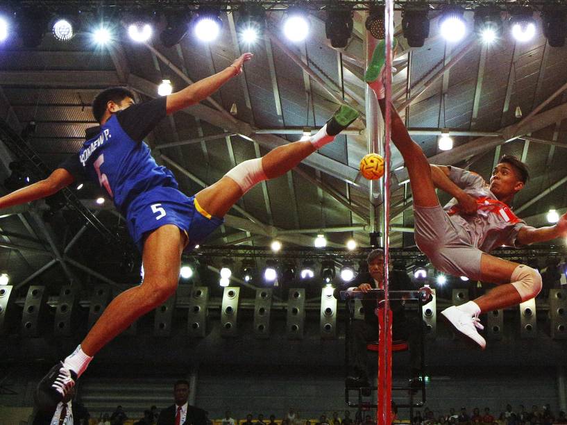 Atletas saltam durante competição de sepaktakraw em Singapura